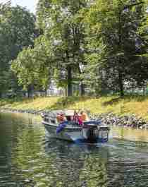 En båt kjører i rolig fart gjennom Hortenskanalen en sommerdag