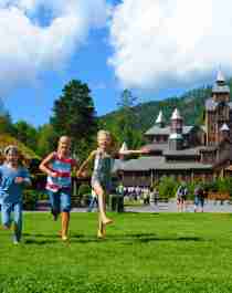 Children running in front of the Fairy tale castle in Hunderfossen family park in the Lillehammer region, Eastern Norway