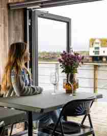 A woman enjoying the view from the restaurant at OlsenNaustet, Veiholmen