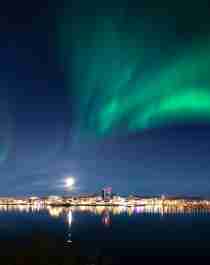 The northern lights dancing across the sky above the city of Bodø, Northern Norway