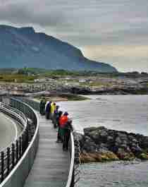 A group of people fishing from the Myrbærholmen fishing bridge on The Atlantic Road in Fjord Norway.