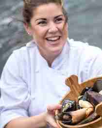 A renowned chef holding a bucket of fresh seafood from Fosen in Trøndelag