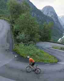 En person cyklar uppför Stalheimskleiva, en av Norges 5 bästa cykelleder i fjällmiljö, i Voss i regionen Fjord Norge (Vestlandet)