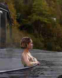 En kvinne nyter et bad i spaet hos Juvet Landskapshotell, Norge.