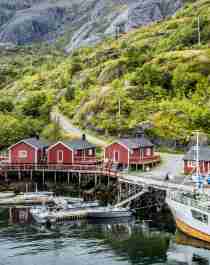 Boats and red fisherman's cabins along the small harbour of Nusfjord in Lofoten, Northern Norway