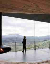 A person looking at the view from inside the Viewpoint Snøhetta in Hjerkinn.