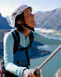 En dame klatrer en fjellvegg i Loen
