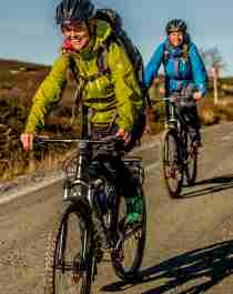 Tre persone in bicicletta lungo una strada sterrata sull’altopiano di Hardangervidda in Norvegia