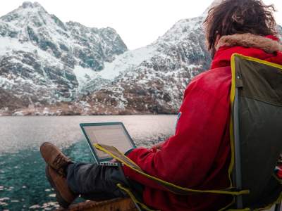 A man working outdoors by the sea at the Arctic Coworking Lodge in Lofoten, Northern Noway
