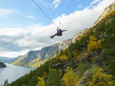 Woman sliding down a zipline near Trolltunga in Fjord Norway