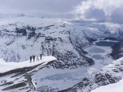 Four people with snowshoes at Trolltunga in Fjord Norway