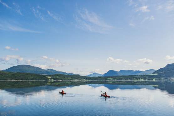 Двое каякеров на Олвунд-фьорде в Сюнндале (Регион фьордов) в солнечный день