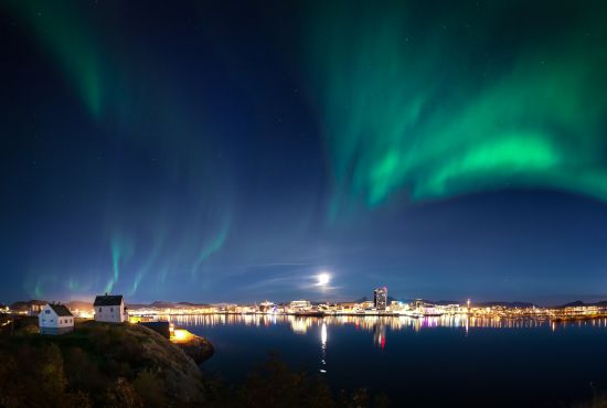 The northern lights dancing across the sky above the city of Bodø, Northern Norway
