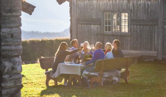 Gruppo di persone cena all’aperto a Brekkeseter sui monti Rondane, Norvegia orientale
