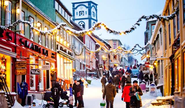 Mensen die door een besneeuwde straat lopen tijdens een kerstmarkt in Røros, Trøndelag, Noorwegen