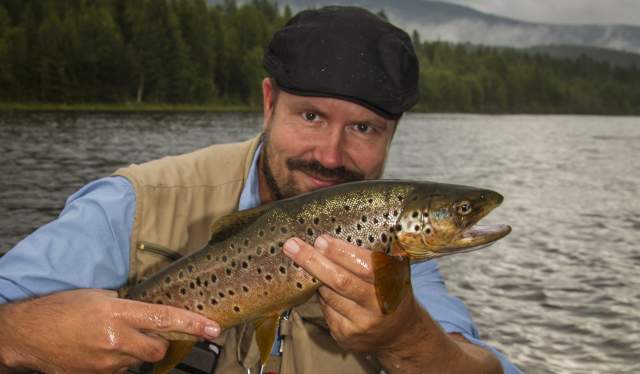 Teacher in fly fishing, Tore Litlere Rydgren in a river holding a fish
