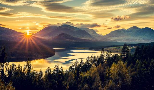 Overview of the mountains, trees and the fjord in Rondane national park, Eastern Norway, at sunset.