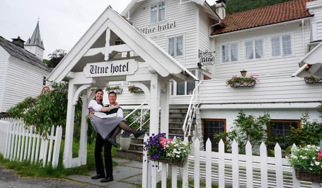 Bente R. and Kjetil Widding, owners of Utne Hotel, standing outside the hotel in the Hardangerfjord region in Fjord Norway