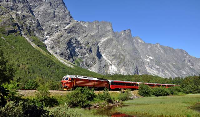 A train on the Rauma Railway in the sunny mountain landscape, Fjord Norway