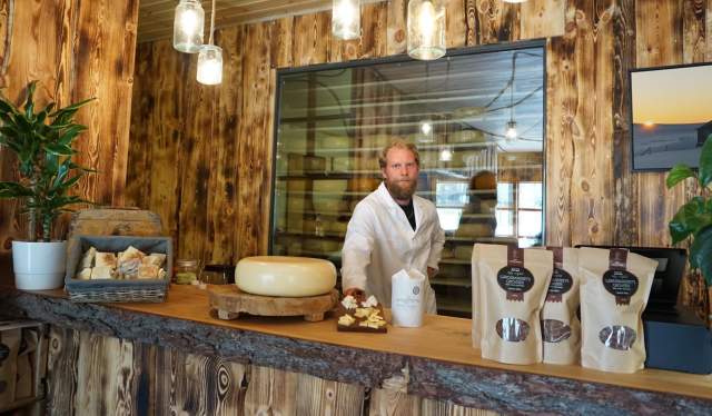 A man standing behind the counter inside the cheese factory Hol Ysteri in Hallingdal, Eastern Norway