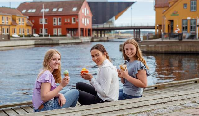 Three young girls eating ice cream on the fish quay in Kristiansand, Southern Norway
