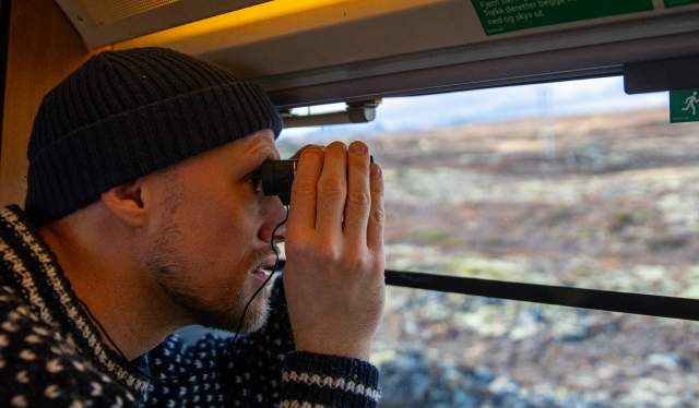 A man looking at the view from the Dovre Railway train
