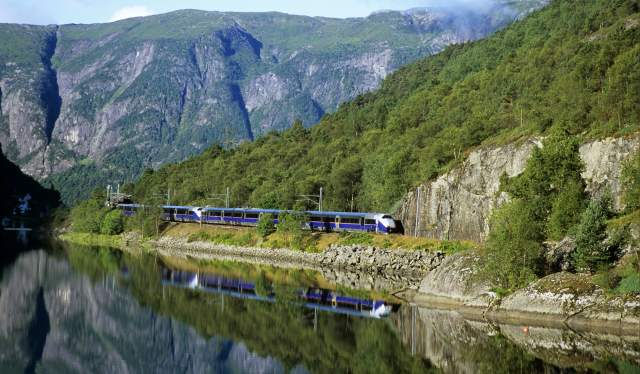 A train riding on the Bergen Railway along the water, Fjord Norway