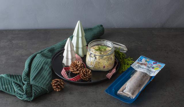 Traditional Norwegian pickled herring in a glass jar.