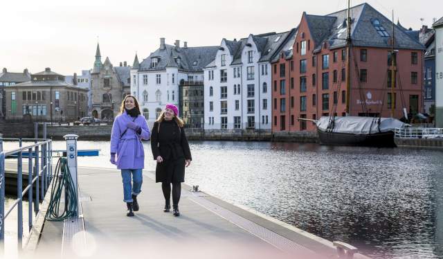 Two women walking along the Brosundet strait in the art noveau city Ålesund
