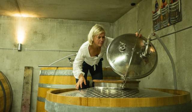 Ingeborg Lindheim standing on a oak barrel in the cider- and beer cellar.