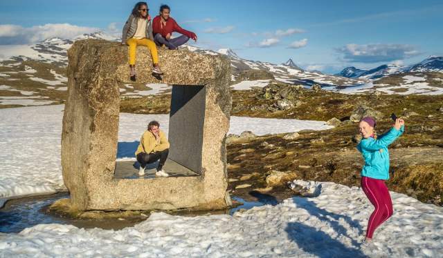 Four friends on an art installation on Norwegian Scenic Route Sognefjellet in Fjord Norway