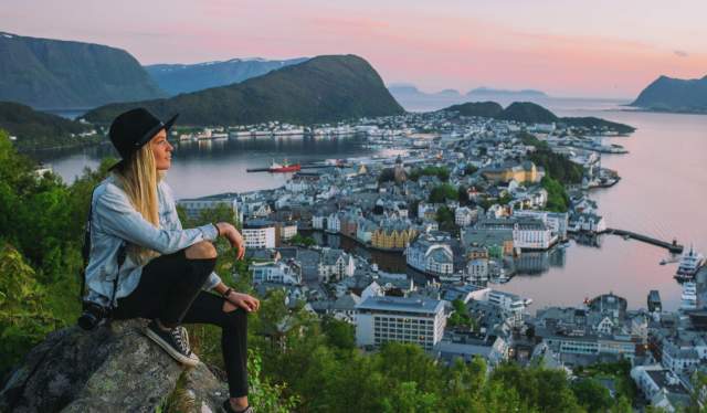 A woman on a city break in Norway is overlooking Ålesund from Aksla viewpoint