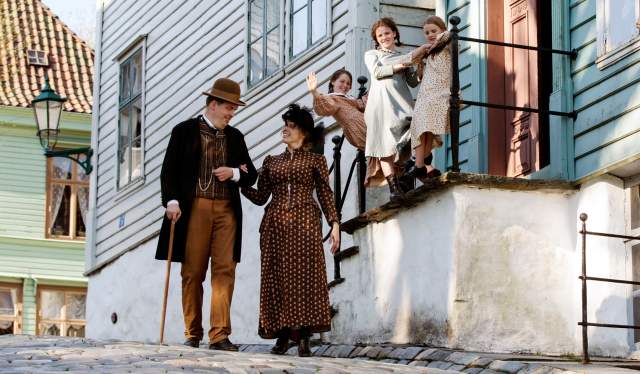A group of people dressed in clothes dating back to the 19th century, as part of the Old Bergen City Museum in Bergen, Fjord Norway