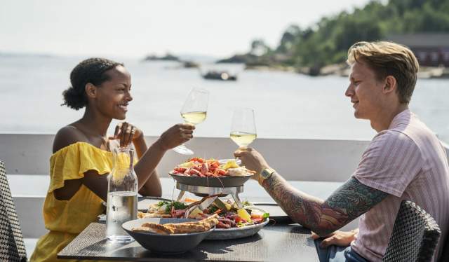 Et forelsket par nyter sjømat på restaurant i Kristiansand