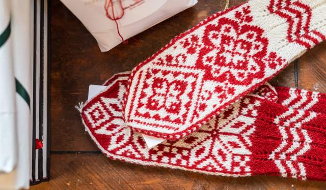 Red and white Selbu mittens on a table, Trøndelag, Norway.
