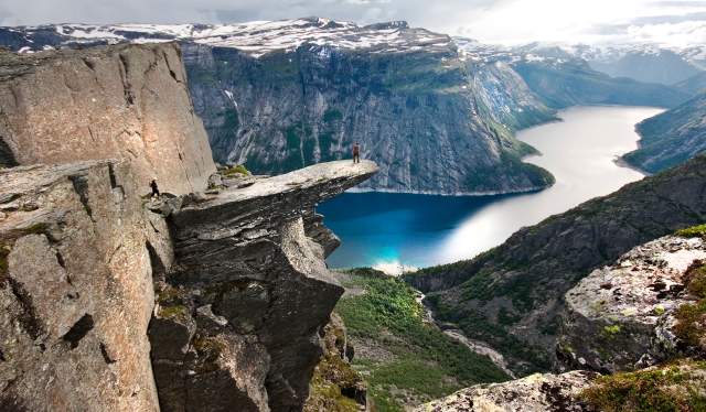 Una persona admira las vistas del lago Ringedalsvatnet desde lo alto de la famosa formación Trolltunga, en Hardanger, la Noruega de los fiordos.