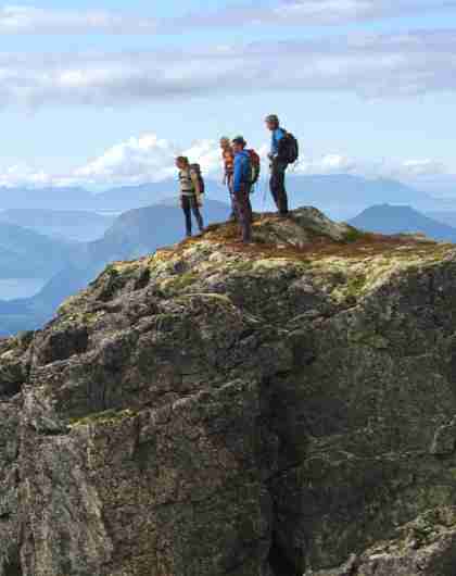 A group of people admire the view from Romsdalseggen in Fjord Norway