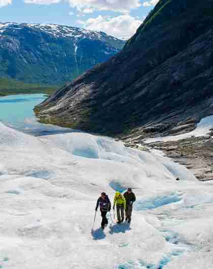 Three people hiking on the Nigardsbreen glacier in Fjord Norway