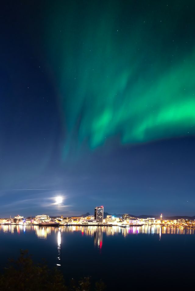 The northern lights dancing across the sky above the city of Bodø, Northern Norway