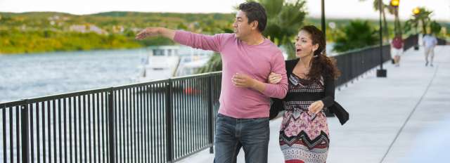 A couple walking along the Laughlin Riverwalk