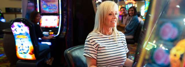 A woman having a great time playing slots at Tropicana Laughlin Hotel and Casino in Laughlin, Nevada!