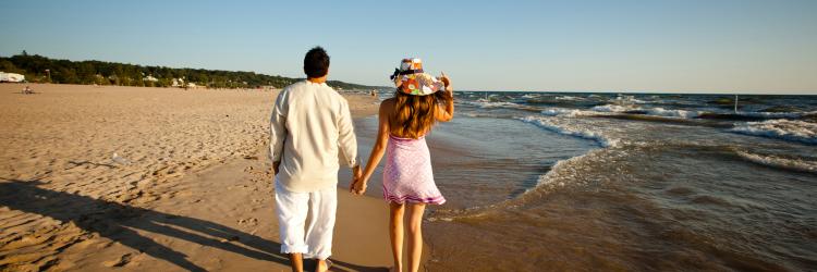 Copy of Beach couple walking Enjoy a day at any number of beach towns in West Michigan, less than an hour drive from Grand Rapids.