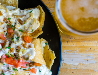 A plate of Brewery Vivant's duck nachos and a pint of beer.
