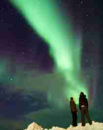 A couple enjoying the beautiful northern lights in Finnmark, Northern Norway