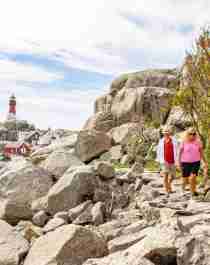 A man and a woman is walking back from the Svenner light house in Stavern, Larvik