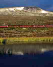 Train riding through a mountain landscape, near the water in Northern Norway