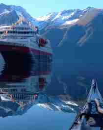 View of the Hurtigruten ship MS Nordlys from a kayak at Hjørundfjorden in Fjord Norway