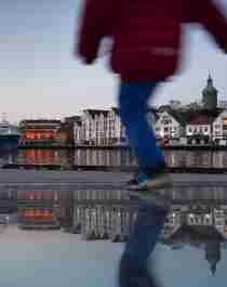 A person running by the wharf with Stavanger as a backdrop in Fjord Norway