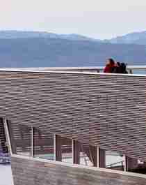 A couple overlooking Tromsø from a viewing point at a tall building