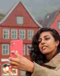A woman taking a selfie at Bryggen in Bergen